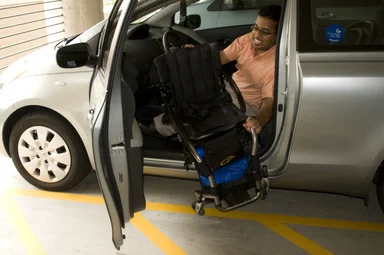 Free Stock Photo: A disabled man in a wheelchair getting out of a car