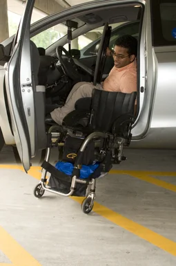 Free Stock Photo: A disabled man in a wheelchair getting out of a car