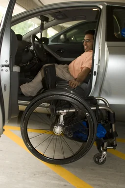 Free Stock Photo: A disabled man in a wheelchair getting out of a car