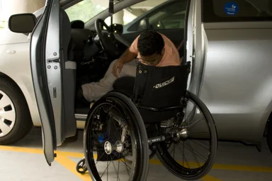 Free Stock Photo: A disabled man in a wheelchair getting out of a car