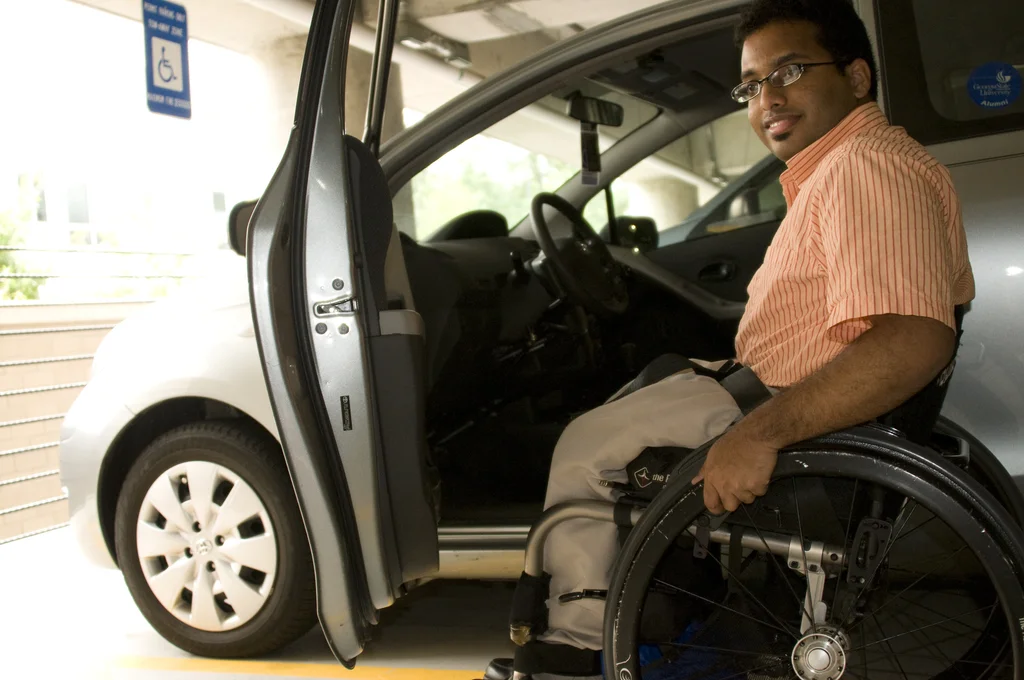 A disabled man in a wheelchair getting out of a car : Free Stock Photo