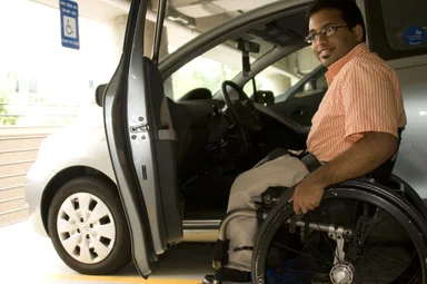 Free Stock Photo: A disabled man in a wheelchair getting out of a car