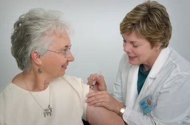 Free Stock Photo: A nurse giving a middle-aged woman a vaccination shot