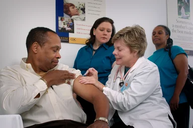 Free Stock Photo: A nurse giving a middle-aged man a vaccination shot