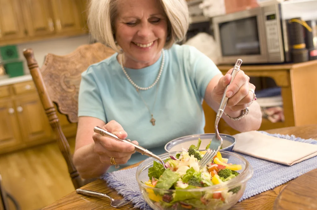 A woman eating a fresh salad : Free Stock Photo