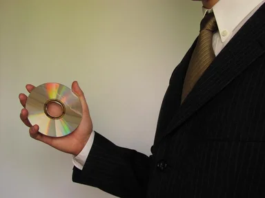 Free Stock Photo: Business man in suit holding a compact disc