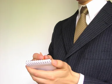 Free Stock Photo: Business man in a suit writing on a memo pad