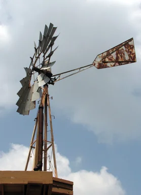 Free Stock Photo: An old farm windmill in a blue cloudy sky