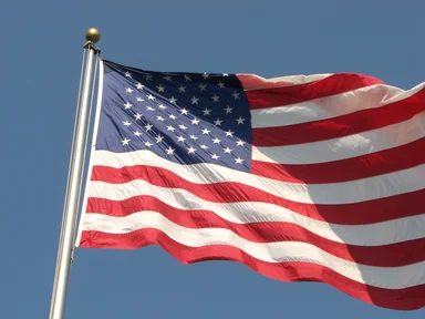 Free Stock Photo: A US flag flying in the wind in a blue sky