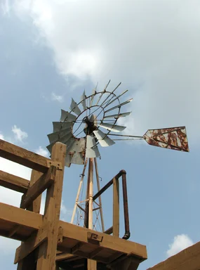 Free Stock Photo: An old farm windmill in a blue cloudy sky