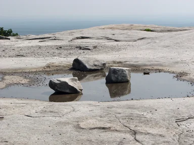 Free Stock Photo: Several rocks in a puddle on top of a mountain