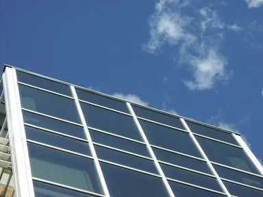 Free Stock Photo: Closeup of modern glass building with blue sky