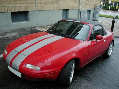 Free Stock Photo: A white striped red Mazda parked on the curb