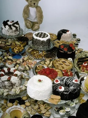 Free Stock Photo: A display of cakes, cookies and other desserts and a teddy bear