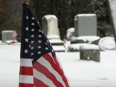 Free Stock Photo: Closeup of a US flag in a snow coverd graveyard