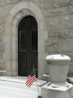 Free Stock Photo: Entrance door of a small stone mausoleum with a US flag