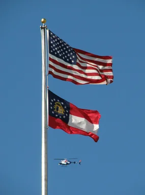 Free Stock Photo: A helicopter flying by a US and Georgia flag