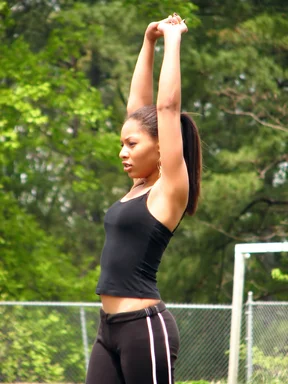 Free Stock Photo: A beautiful teen African American girl stretching on an athletic field