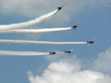 Free Stock Photo: Vintage SNJ-2 WW2 fighter planes flying in formation with smoke trails
