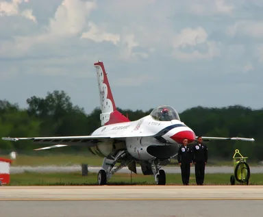 Free Stock Photo: An F-16 Air Force Thunderbird jet with crew members on a runway at the 2009 Robins AFB Air Show.