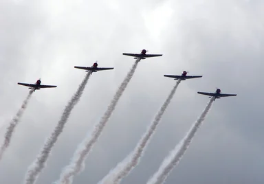 Free Stock Photo: Vintage SNJ-2 WW2 fighter planes flying in formation with smoke trails