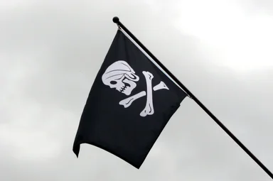 Free Stock Photo: A skull and crossbones pirate flag flying in the sky