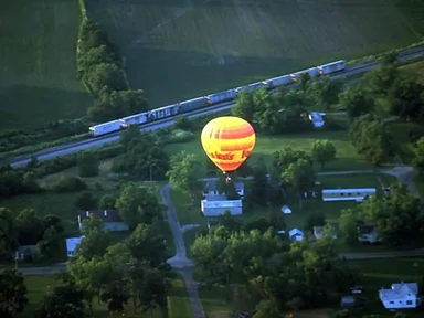 Free Stock Photo: A hot air balloon flying by a train