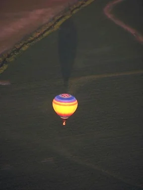 Free Stock Photo: A hot air balloon flying over a field