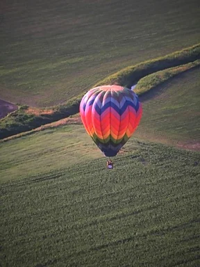 Free Stock Photo: A hot air balloon flying over a field