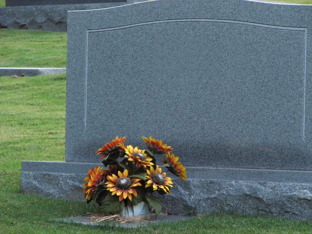 A blank tombstone with flowers : Free Stock Photo