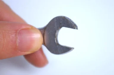 Free Stock Photo: A hand holding a wrench isolated on a white background