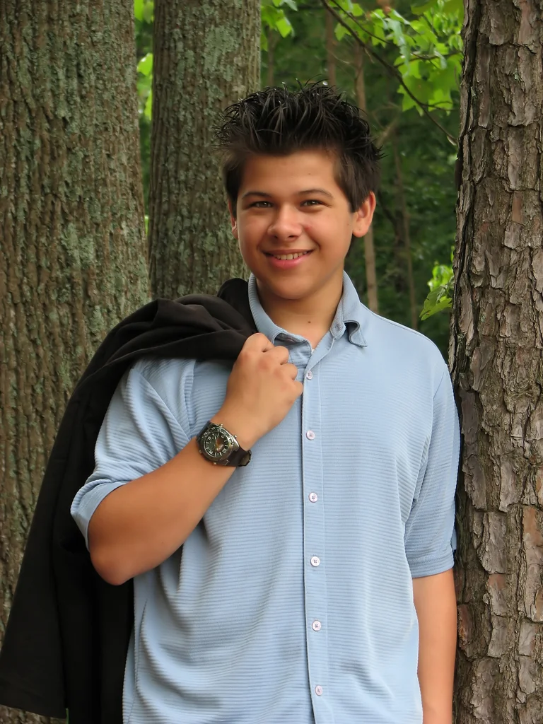 A young latino teen boy posing outdoors by a tree : Free Stock Photo