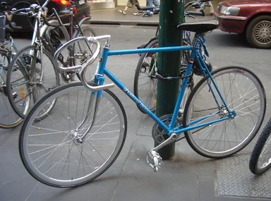 Free Stock Photo: A blue bicycle chained against a pole