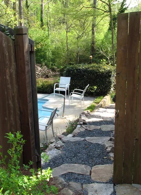Free Stock Photo: A pool and chairs in a backyard behind a fence