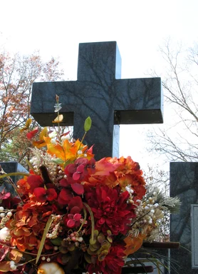 Free Stock Photo: Flowers by a cross in a cemetary