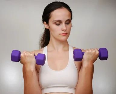 Free Stock Photo: A beautiful young woman exercising with weights