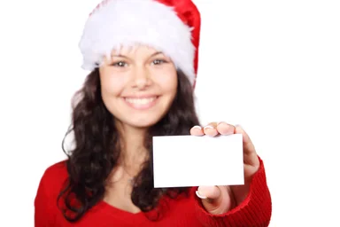 Free Stock Photo: A beautiful young woman with a Christmas hat and a blank business card