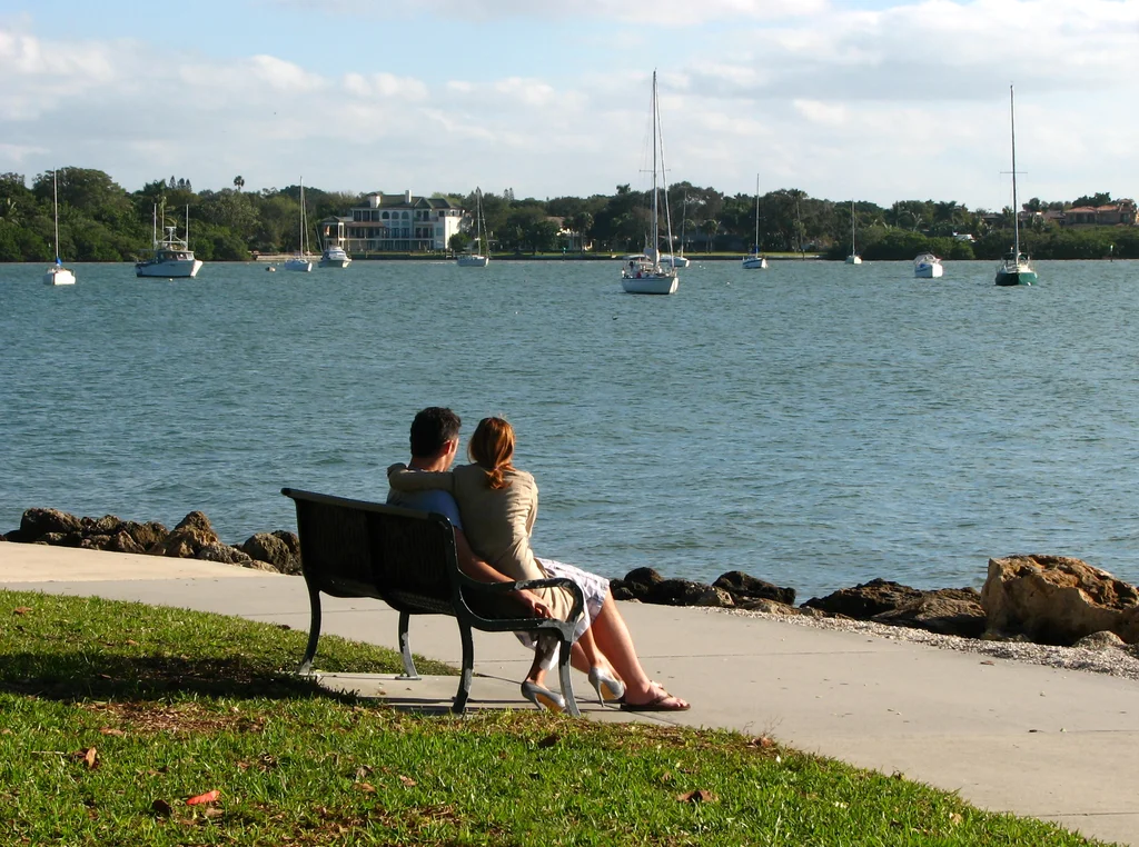 A couple sitting on a bench overlooking the ocean : Free Stock Photo