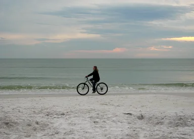 Free Stock Photo: A woman riding a bike on the beach